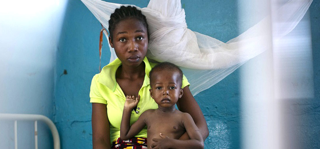 A Liberian woman holding her child at a clinic